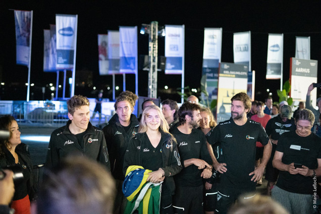 Team Malizia in front of several flags