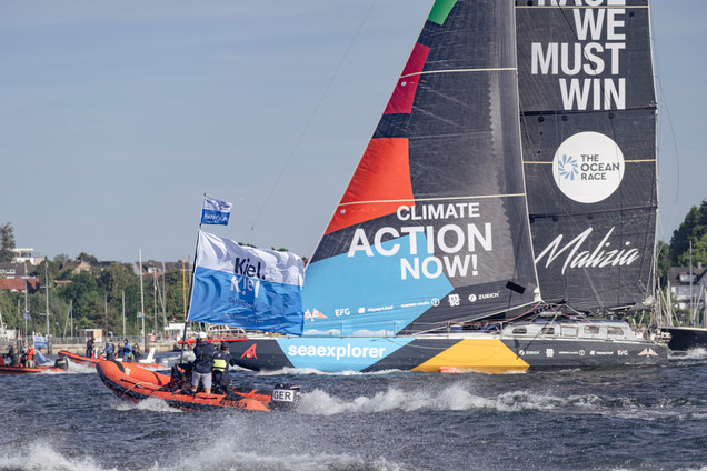 IMOCA vom Team Malizia und RIB mit der Flagge von Kiel-Marketing auf dem Wasser während des Kiel Fly-By