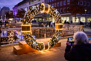 Eine Frau fotografiert ein winterliches Element am Holstenfleet