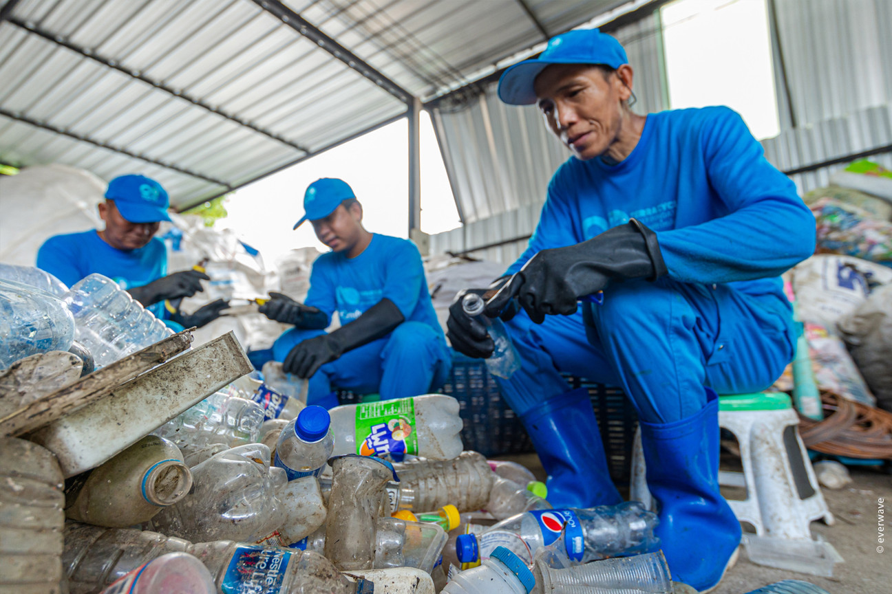 Drei Männer recyceln Plastikmüll